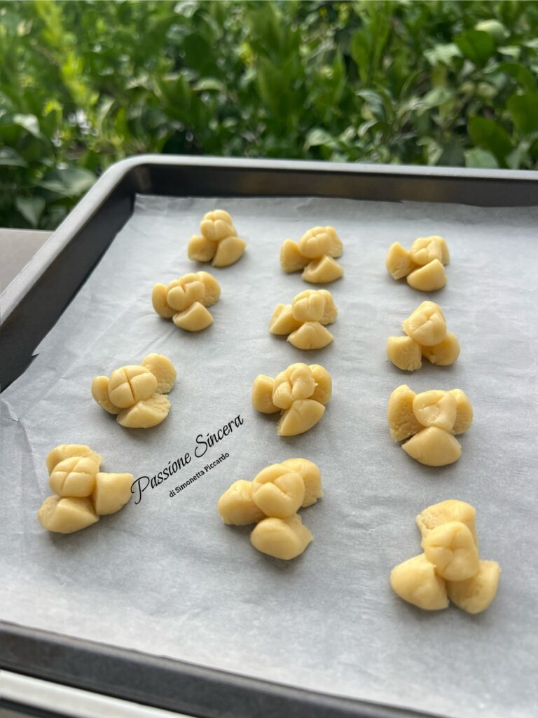 Khanom Kleeb Lamduan, biscotti thailandesi a forma di fiore disposti sulla carta da forno prima della cottura